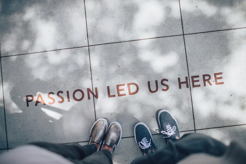 Scritta “Passion led us here” sul marciapiede